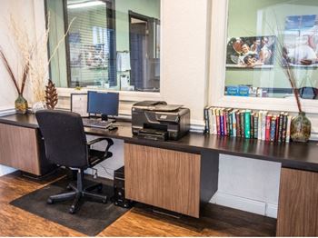 A desk with a computer and printer on it